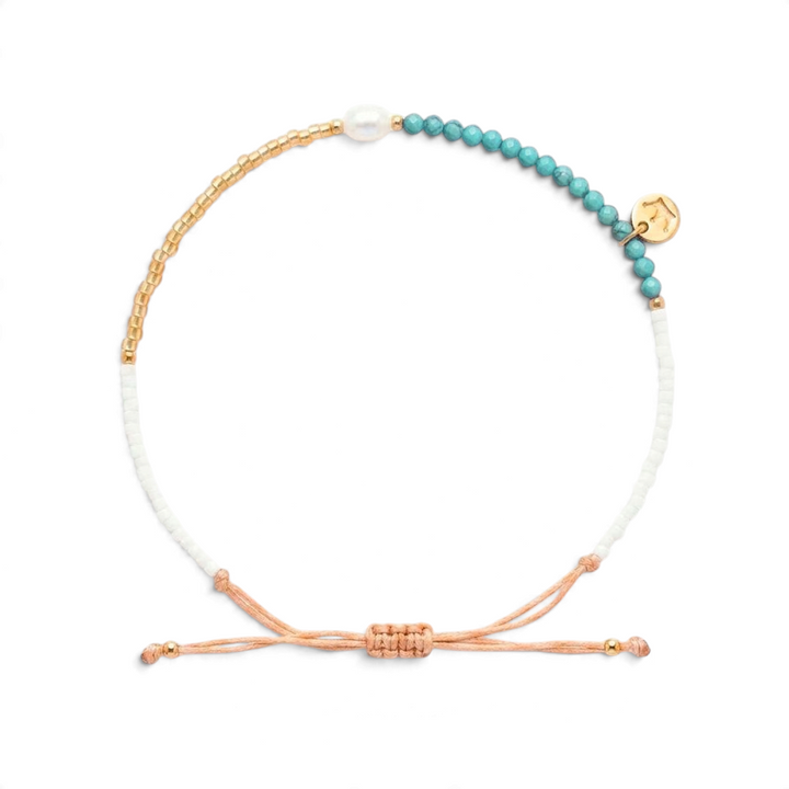 Niche Jewellery Jersey Pearl Noma bracelet featuring turquoise and white beads with a freshwater pearl and gold charm.
