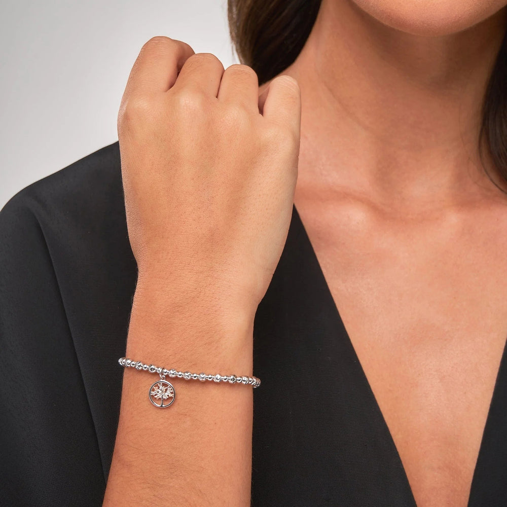 Niche Jewellery: Clogau Sterling silver beaded bracelet with rose gold Tree of Life charm seen on model, symbolizing growth and connection.