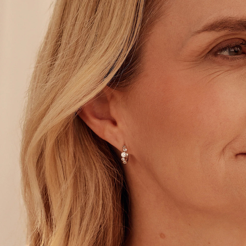 Niche Jewellery: Clogau Sterling silver huggie hoop earrings with rose gold accents and white topaz stones, inspired by bubbles.