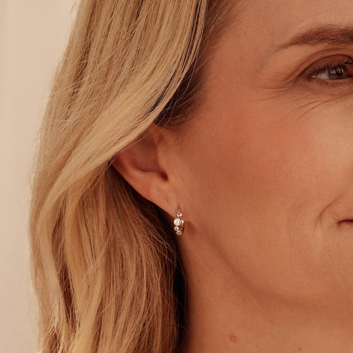 Niche Jewellery: Clogau Sterling silver huggie hoop earrings with rose gold accents and white topaz stones, inspired by bubbles.