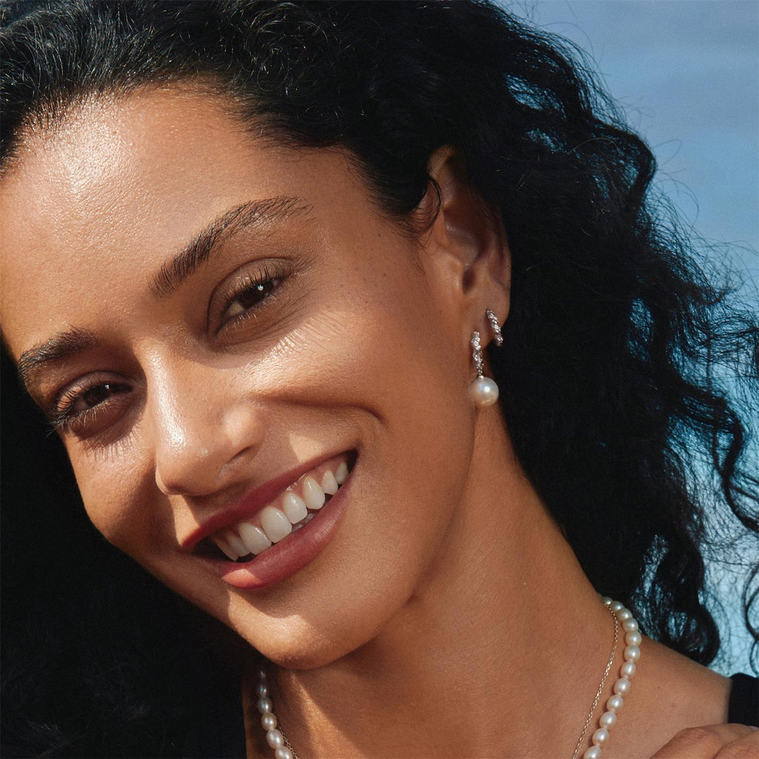 Niche Jewellery Ania Haie Shell Pearl Dangling Twisted Huggie Hoop Silver Earrings worn on model