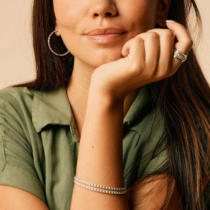 Niche Jewellery Charlotte's Web sterling silver Maharani stacking bangle with signature bubble detailing on a model