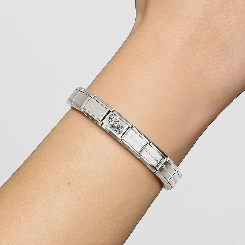 Niche Jewellery Nomination silver Statue of Liberty charm on a classic stainless steel link bracelet on a wrist.
