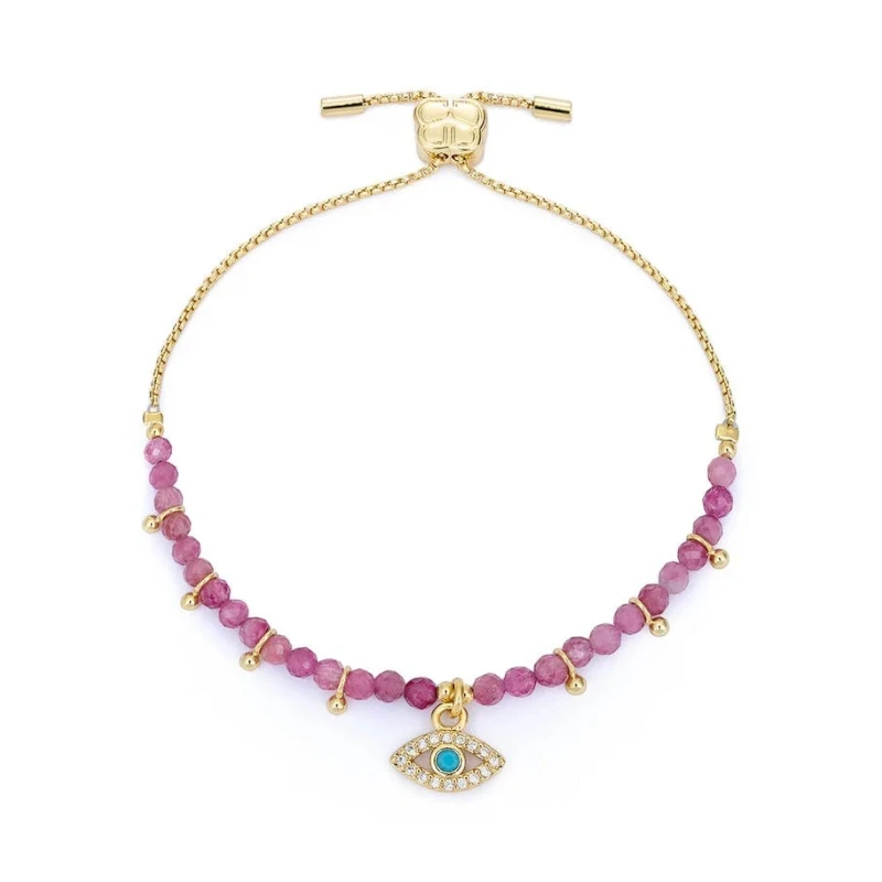 Gold bracelet with pink beads and a blue evil eye charm on a white background