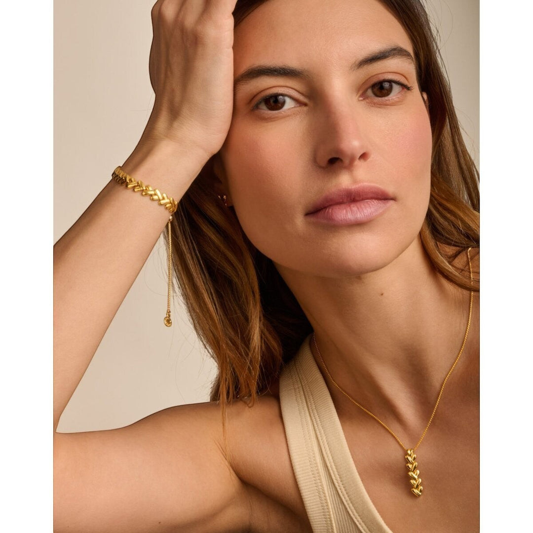 Niche Jewellery Katie Loxton gold necklace with a vertical row of five heart-shaped links on a delicate chain. Waterproof and sweat-proof.