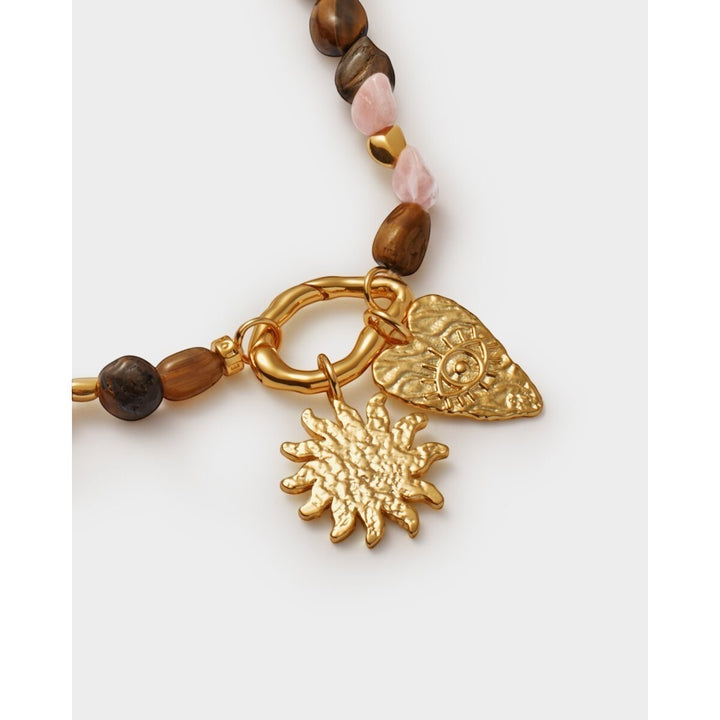 Niche Jewellery: Katie Loxton Sunset Solesi necklace with gold PVD coating, tiger's eye and rose quartz beads, and sun and eye charms.