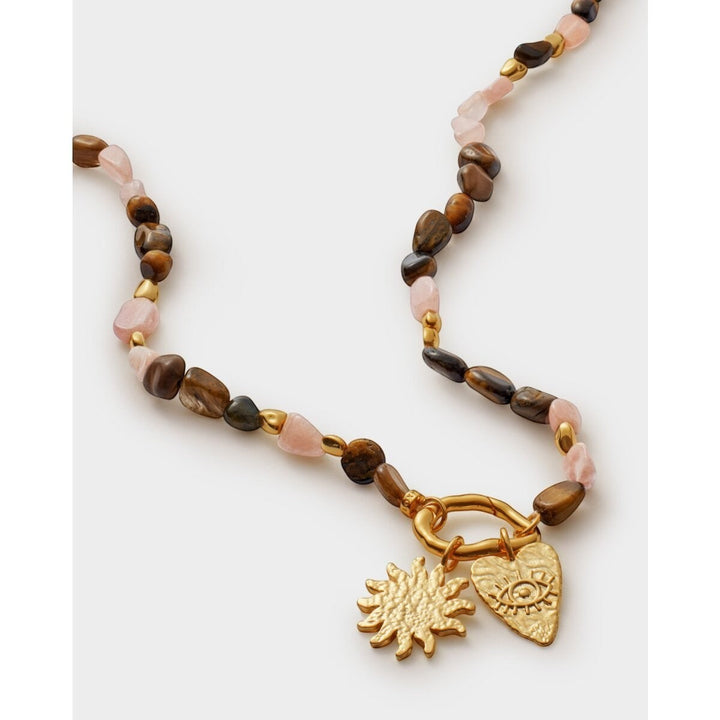 Niche Jewellery: Katie Loxton Sunset Solesi necklace with gold PVD coating, tiger's eye and rose quartz beads, and sun and eye charms.
