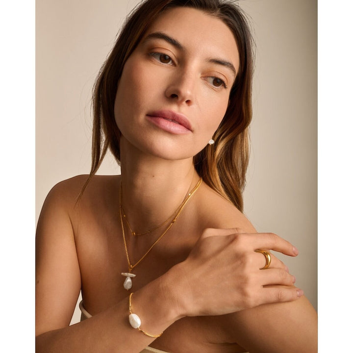 Niche Jewellery: Katie Loxton Sol Pearl bracelet with freshwater pearl and gold hearts on a gold chain.