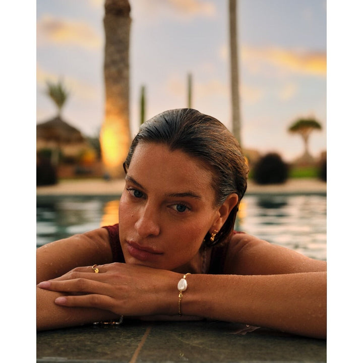 Niche Jewellery: Katie Loxton Sol Pearl bracelet with freshwater pearl and gold hearts on a gold chain.