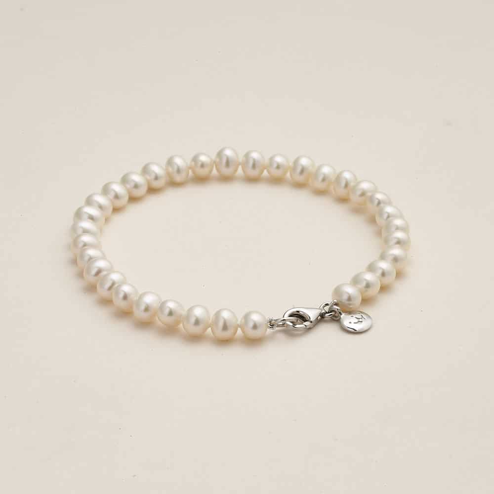 Niche Jewellery Jersey Pearl 5mm freshwater pearl bracelet with a silver clasp and signature charm on a neutral background