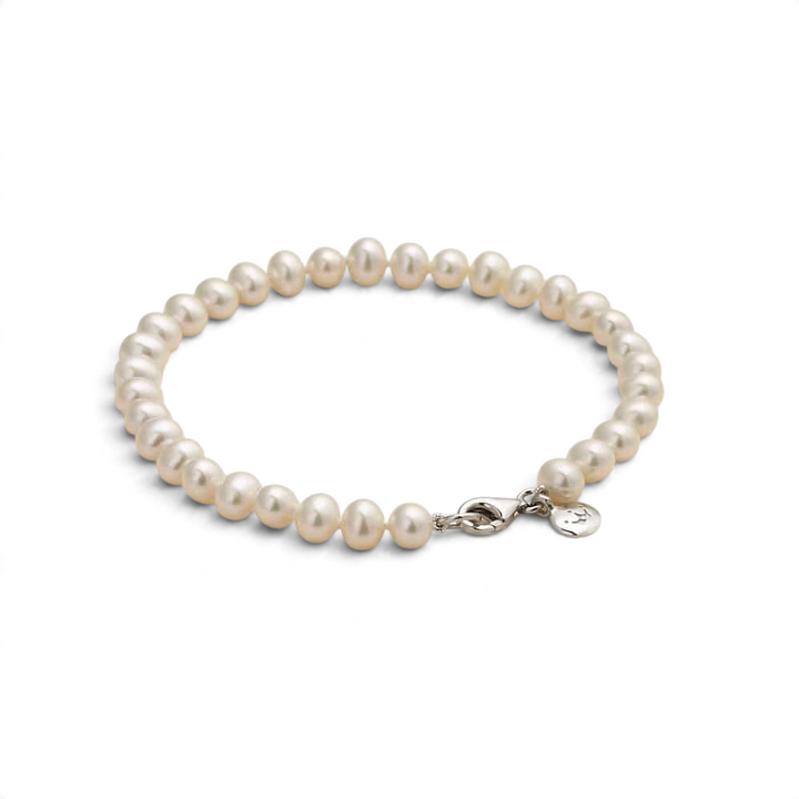 Niche Jewellery Jersey Pearl 5mm freshwater pearl bracelet with a silver clasp and signature charm on a neutral base.