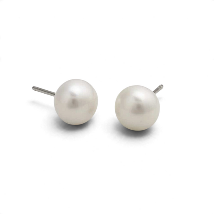 Niche Jewellery 9mm button-shaped freshwater pearl stud earrings set in sterling silver on a white background.