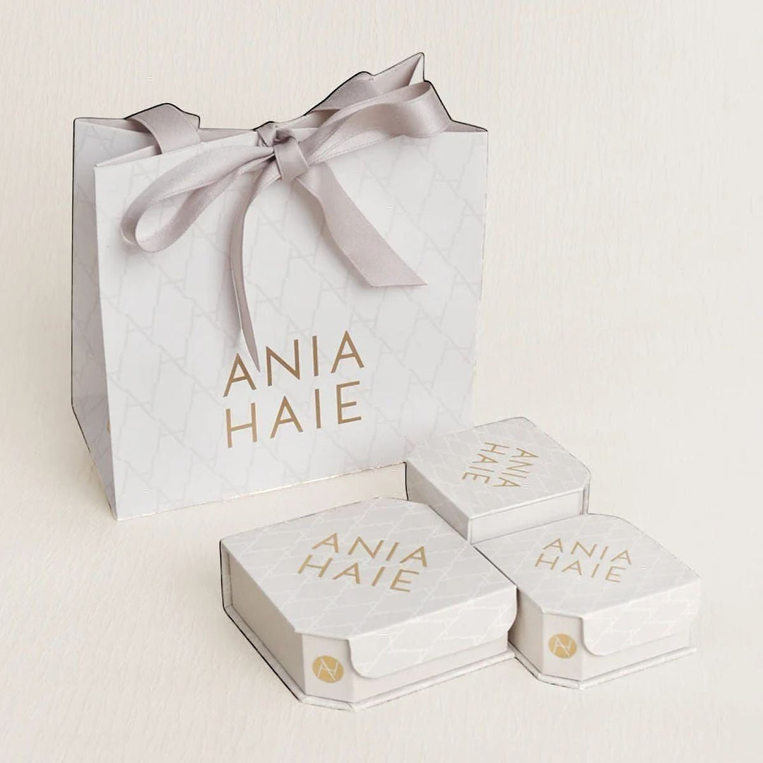 Niche Jewellery branded Ania Haie gift bag and three white jewellery boxes with gold logo branding