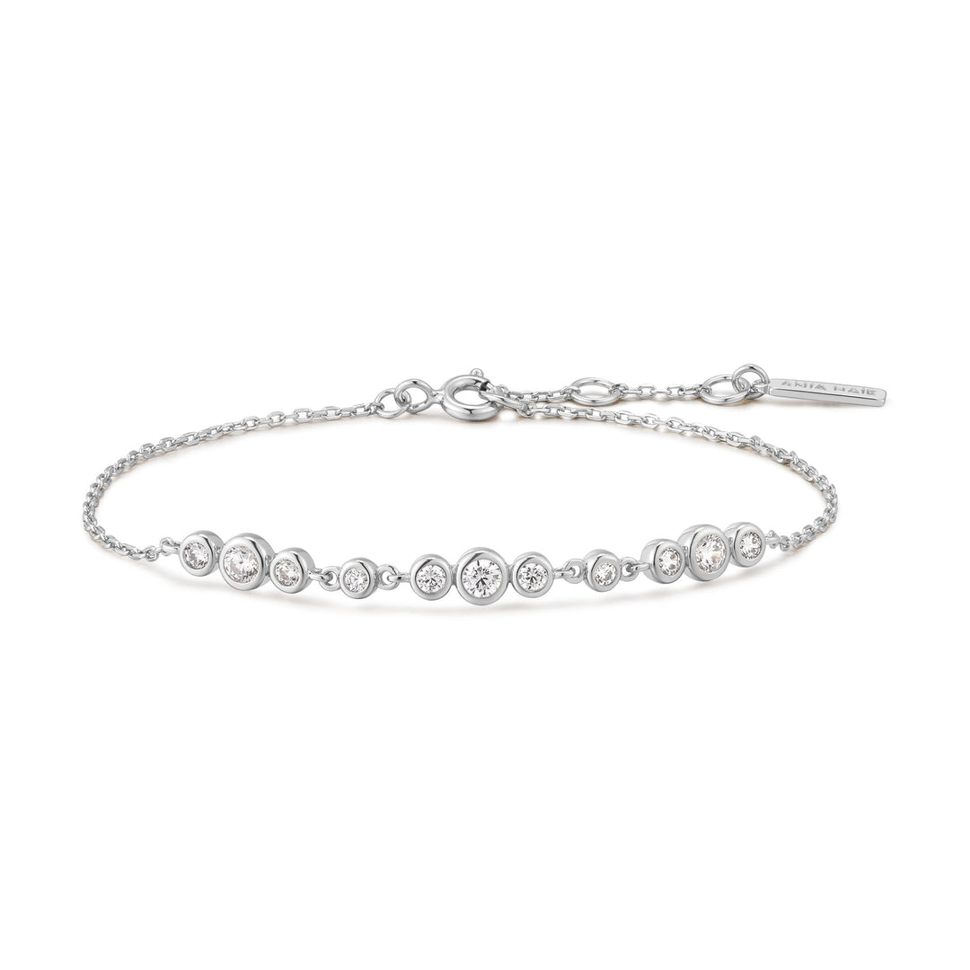Niche Jewellery Ania Haie rhodium-plated sterling silver bracelet with graduated bezel-set cubic zirconia trios.