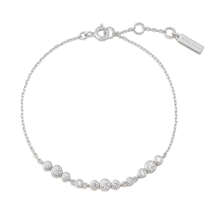 Niche Jewellery Ania Haie rhodium-plated sterling silver bracelet with graduated bezel-set cubic zirconia trios.
