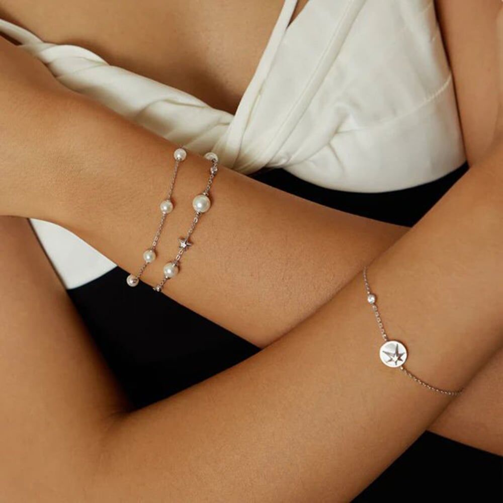 Niche Jewellery Ania Haie rhodium-plated sterling silver bracelet featuring delicate shell pearls and star charms.