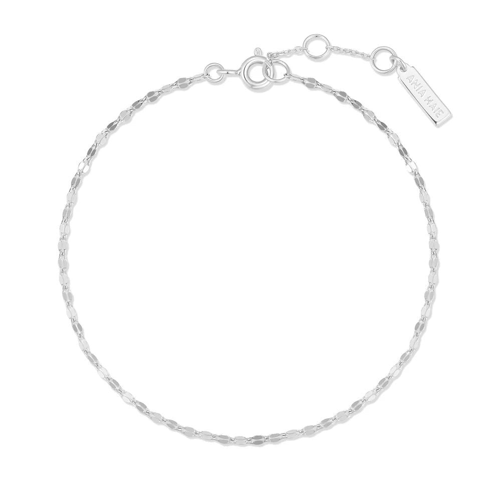 Niche Jewellery Ania Haie silver bracelet featuring a delicate textured chain and a small branded logo tag