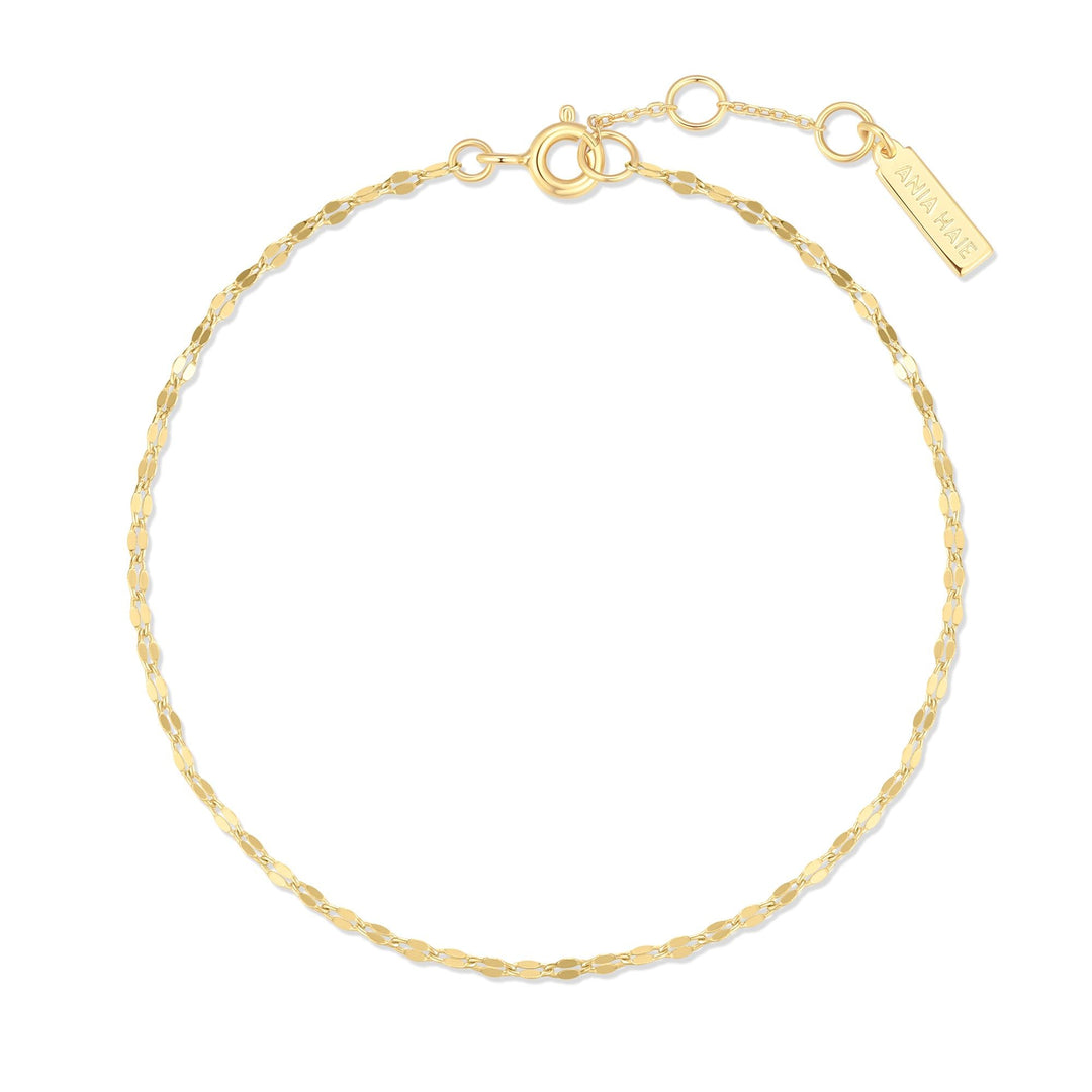 Niche Jewellery Ania Haie gold bracelet featuring a delicate textured chain and a small branded rectangular tag