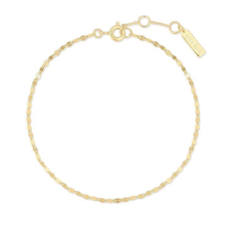 Niche Jewellery Ania Haie gold bracelet featuring a delicate textured chain and a small branded rectangular tag
