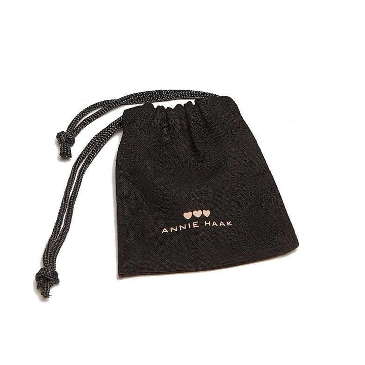 Niche Jewellery black fabric drawstring pouch with Annie Haak logo and three heart icons in white print