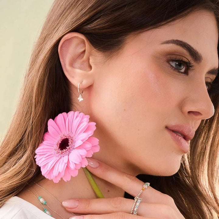 Niche Jewellery Annie Haak sterling silver hoop earrings featuring a delicate butterfly charm worn by a woman