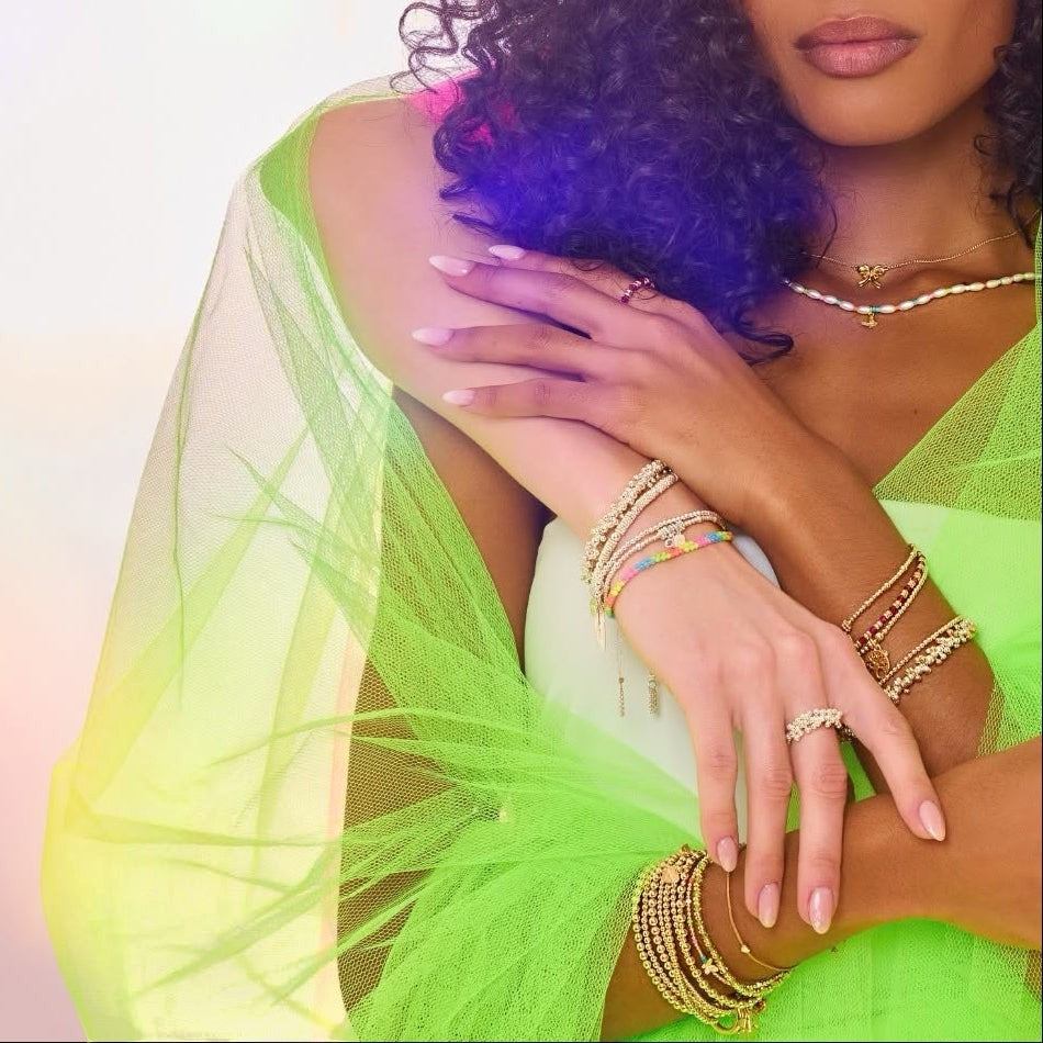 Niche Jewellery Annie Haak Papillon gold bracelet with neon beads and butterfly charm worn on a model in neon tulle