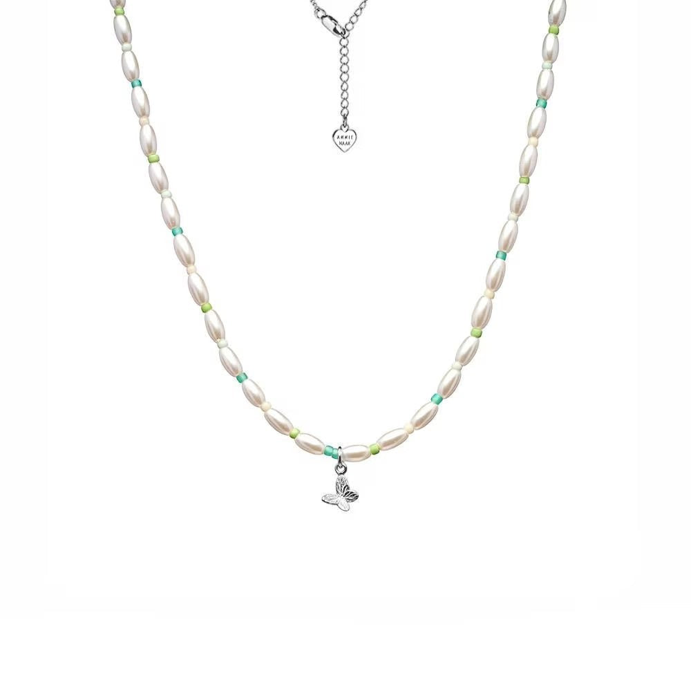 Niche Jewellery Annie Haak Papillon necklace featuring a sterling silver butterfly charm, pearls, and turquoise beads.