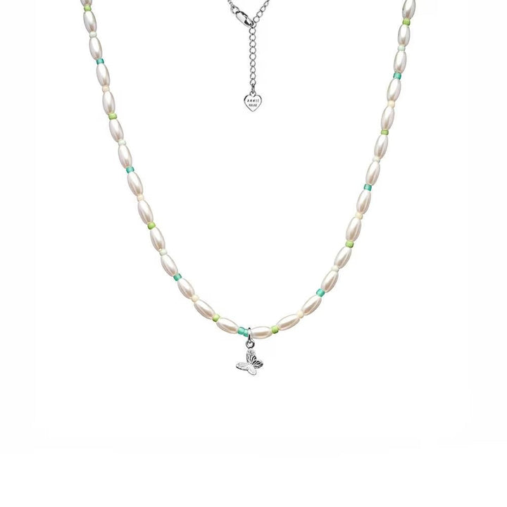 Niche Jewellery Annie Haak Papillon necklace featuring a sterling silver butterfly charm, pearls, and turquoise beads.