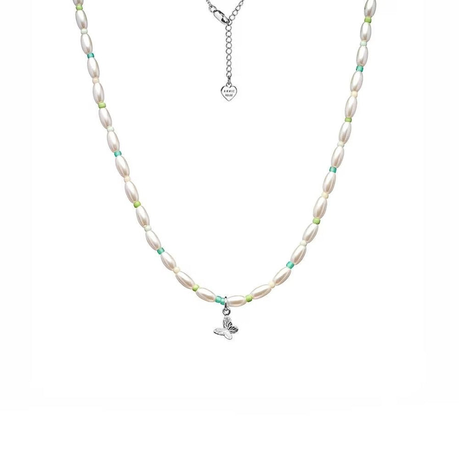 Niche Jewellery Annie Haak Papillon necklace featuring a sterling silver butterfly charm, pearls, and turquoise beads.