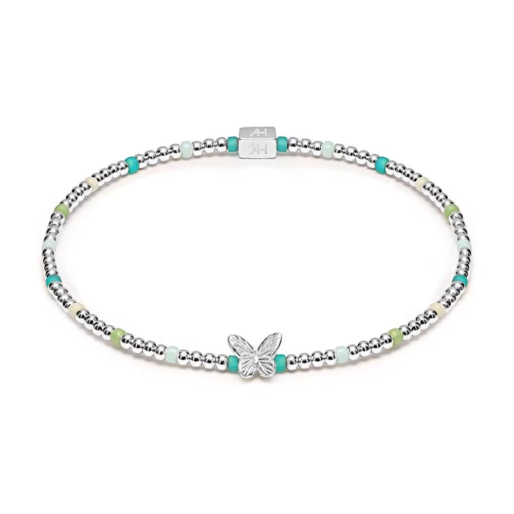 Niche Jewellery Annie Haak Papillon stretch bracelet with sterling silver beads, turquoise glass, and butterfly charm.