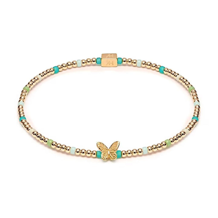 Niche Jewellery Annie Haak Papillon gold-plated stretch bracelet with turquoise, green beads, and butterfly charm.