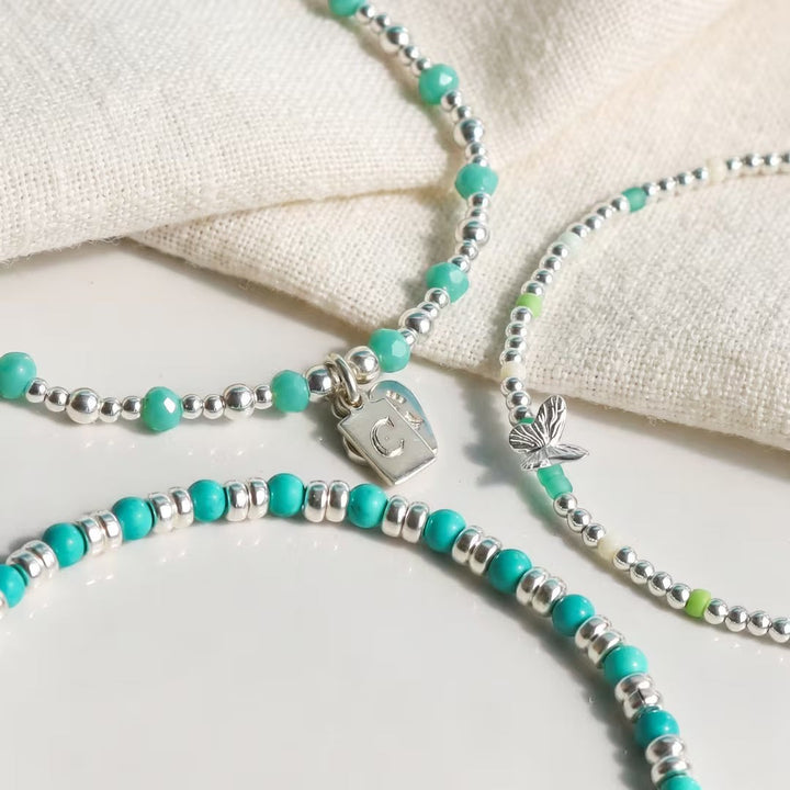 Niche Jewellery Annie Haak Papillon stretch bracelet with turquoise glass beads, sterling silver, and butterfly charm.