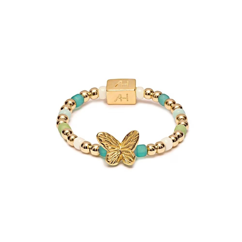 Niche Jewellery Annie Haak Papillon gold-plated butterfly ring with turquoise and green glass beads on stretch band.