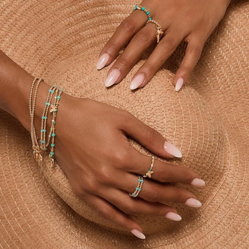 Niche Jewellery Annie Haak Turquoise Duet gold-plated silver ring with turquoise Miyuki beads on a straw hat background