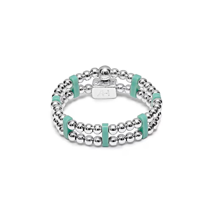 Niche Jewellery Annie Haak sterling silver stretch ring with turquoise Miyuki beads and a branded silver charm.