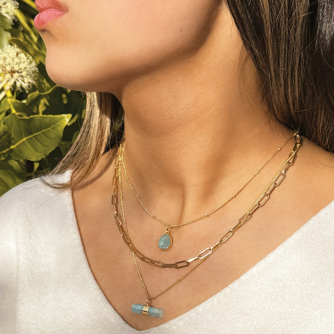 Niche Jewellery Sarah Alexander Aegean aquamarine pendant necklace layered with gold chains on a model