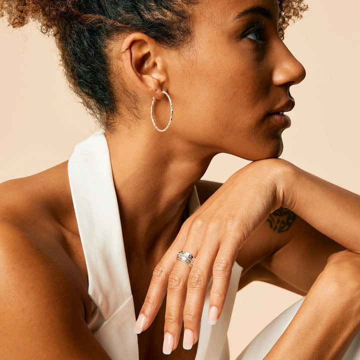 Niche Jewellery Charlotte's Web  Aura Halo spinning ring in recycled sterling silver worn on a model's finger