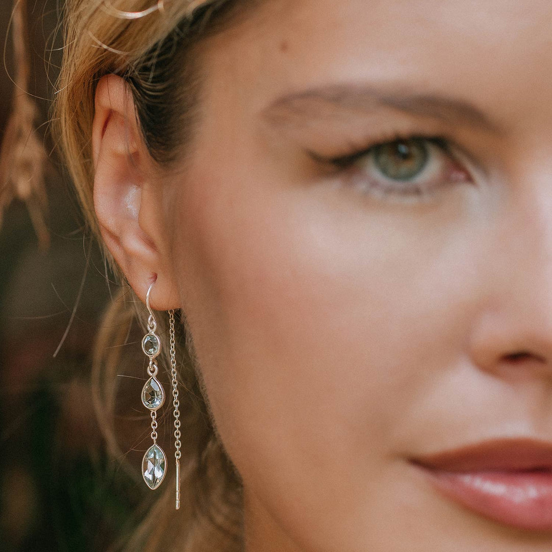 Niche Jewellery Charlotte's Web Azura sterling silver threader earrings with blue topaz stones worn by a woman
