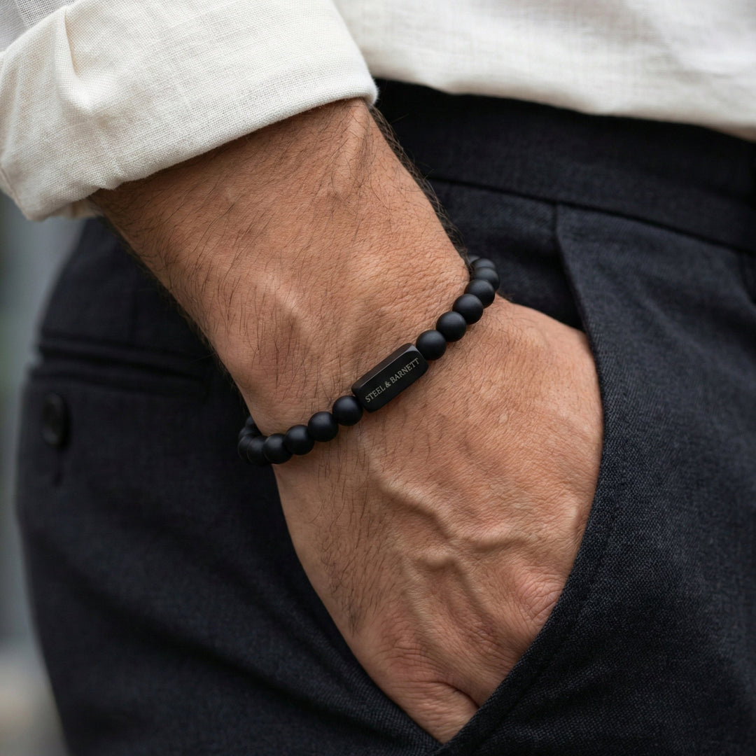 Niche Jewellery Steel & Barnett 6mm matte black onyx bead bracelet with a stainless steel logo accent on a wrist