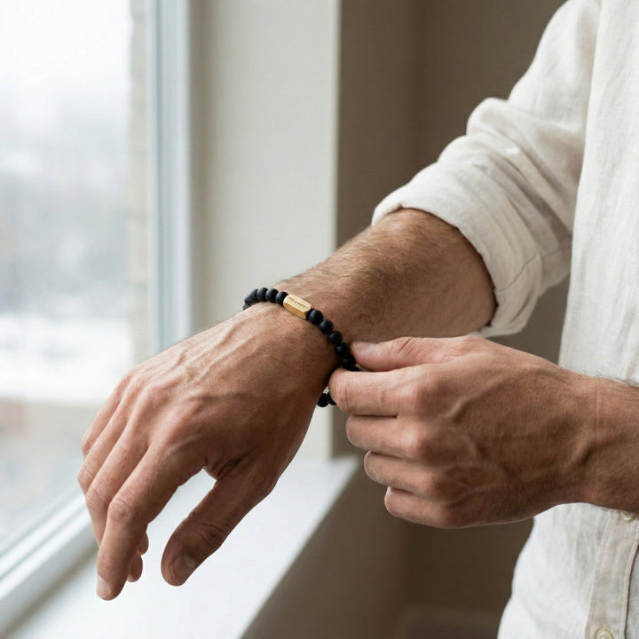 Niche Jewellery Steel & Barnett black onyx bead bracelet with 18K gold plated accent worn on a man's wrist.