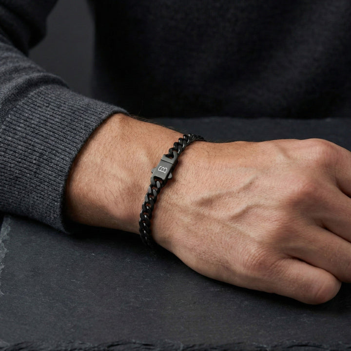 Niche Jewellery Steel & Barnett matte black stainless steel link chain bracelet with branded clasp on a man's wrist.