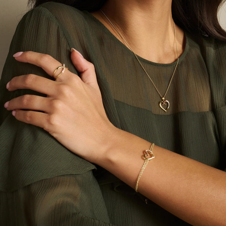 Niche Jewellery Clogau Forever Yours 9ct gold kiss pendant, bracelet, and ring set with diamonds on a woman.