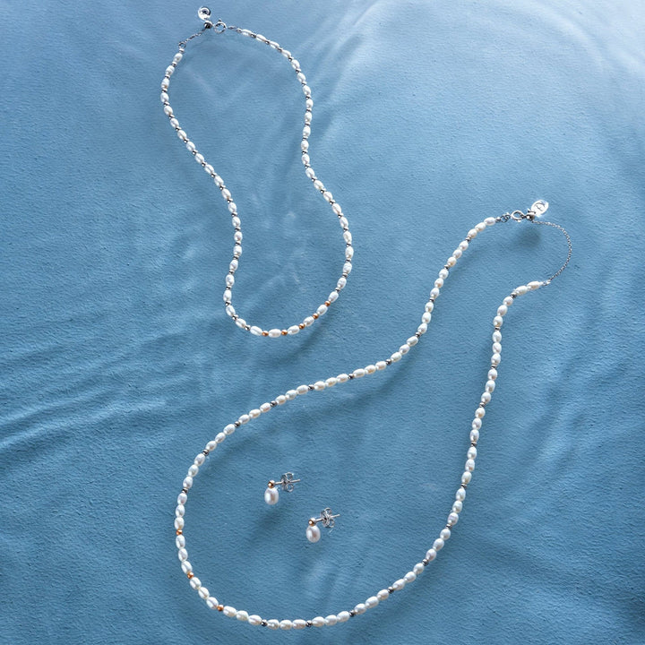 Niche Jewellery Clogau sterling silver and freshwater pearl necklaces and matching stud earrings on blue fabric
