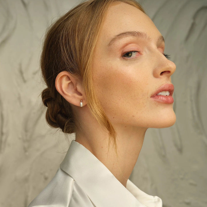 Niche Jewellery Clogau sterling silver stud earrings with freshwater pearls worn by a woman in profile