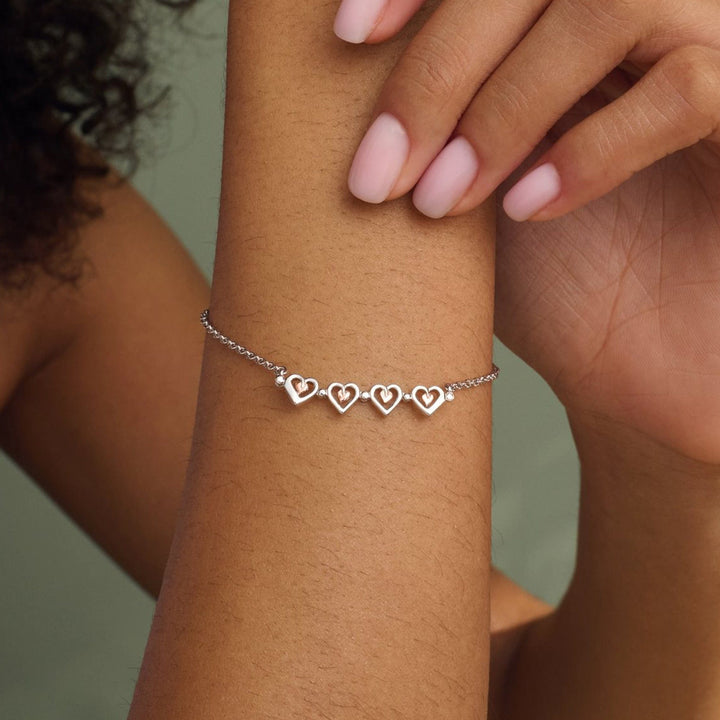 Niche Jewellery Clogau sterling silver heart bracelet with rose gold detail worn on a woman's wrist