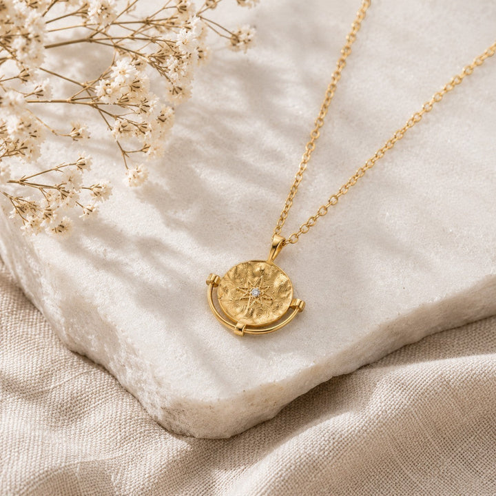 Niche Jewellery Formation Co Cosmic Diamante necklace featuring a gold plated star pendant on a delicate chain on marble stone.