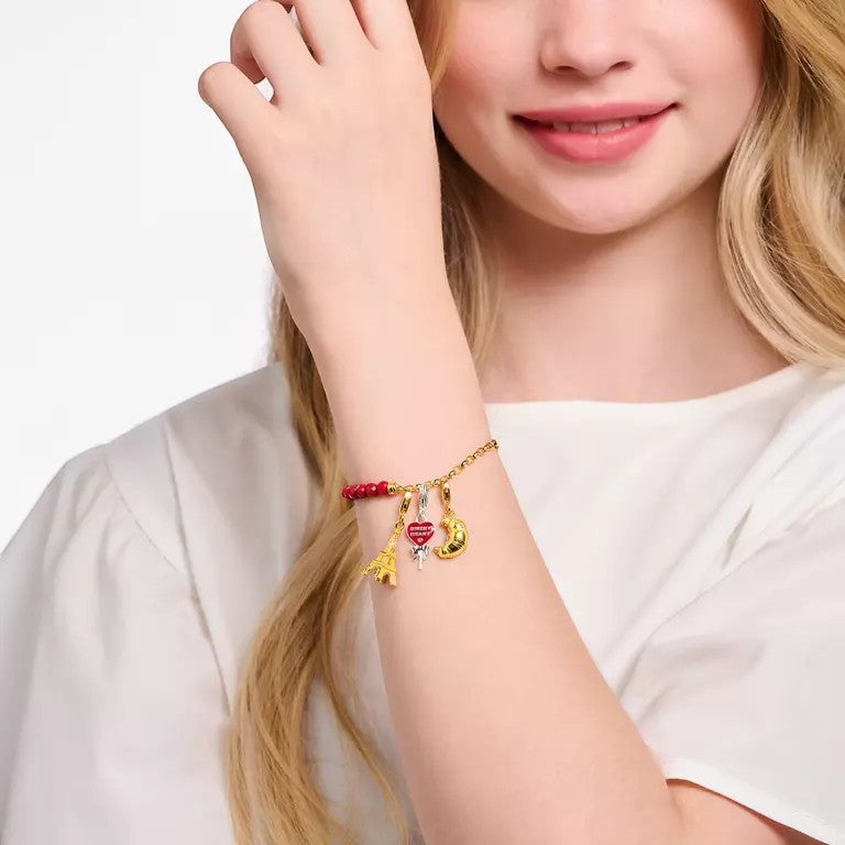 Thomas Sabo gold-plated Eiffel Tower charm pendant with zirconia detail on a charm bracelet.