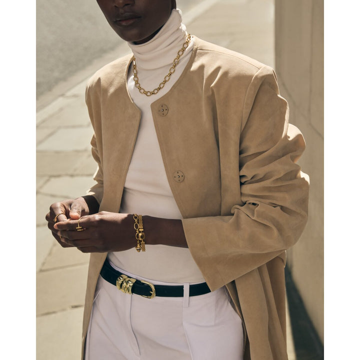 Niche Jewellery Katie Loxton Empire waterproof gold chain bracelet worn on a model in a beige coat and white top