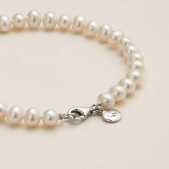 Niche Jewellery Jersey Pearl 5mm freshwater pearl bracelet with a silver lobster clasp and branded charm.