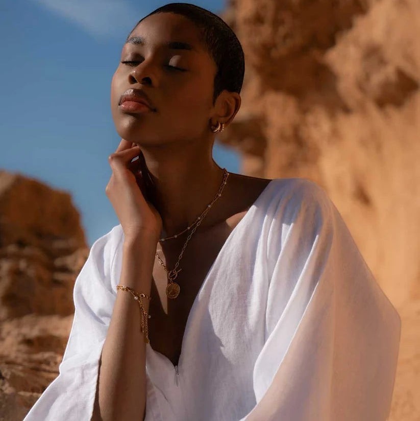 Niche Jewellery Formation Co Gaia pearl necklace featuring freshwater pearls on an 18k gold plated chain worn by a woman outdoors.